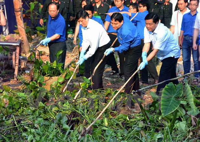 Ông Đinh La Thăng xắn tay cùng thanh niên thu gom rác thải