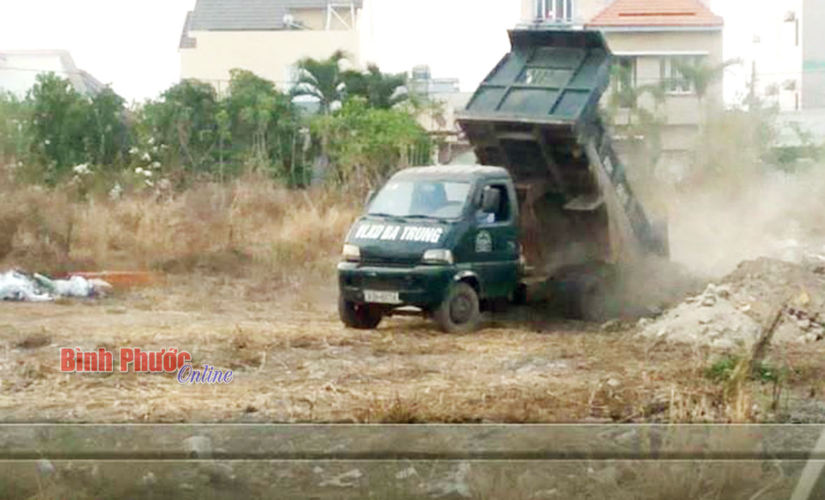 Xe tải biển số 93H-6018 của cơ sở vật liệu xây dựng Bá Trung ngang nhiên đổ chất thải xây dựng ra bãi đất trống (hình cắt từ video)