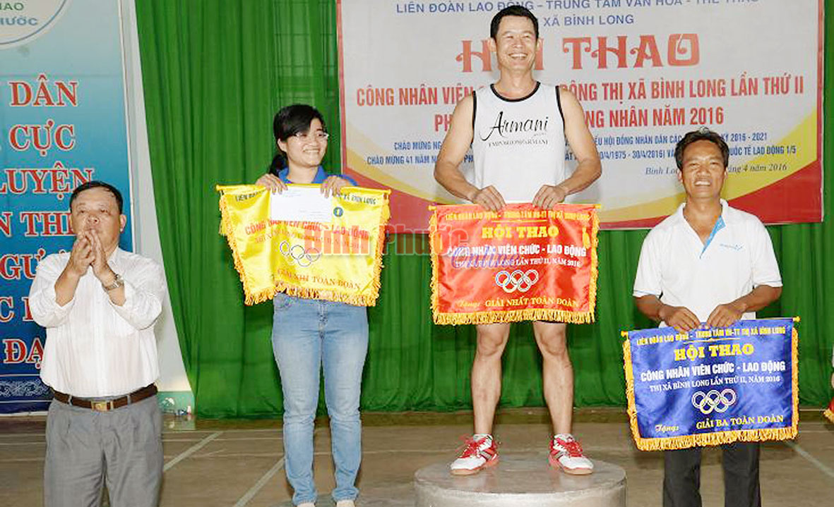 ​Ông Phan Xuân Vĩnh, Phó chủ tịch UBND thị xã Bình Long trao cờ cho các đội đoạt giải nhất, nhì, ba toàn đoàn