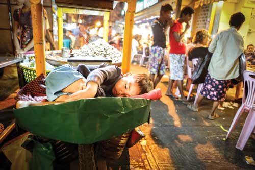 Em bé Myanmar nằm trên xe bán đậu phộng - Ảnh: Nguyễn tập