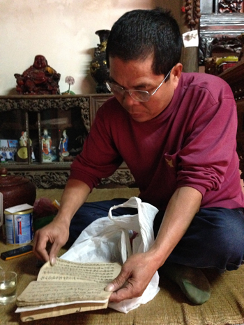 Ông Hà tìm trong gia phả có ghi chép và chứng minh ngôi mộ là của dòng họ Doãn. Ảnh: Hương Thu.