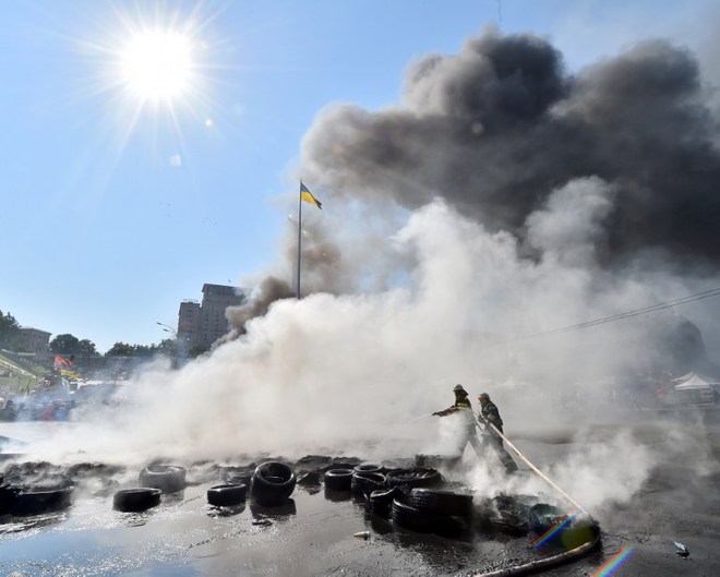 Các nhân viên cứu hỏa vất vả khống chế ngọn lửa trên quảng trường Maidan. Ảnh: AFP