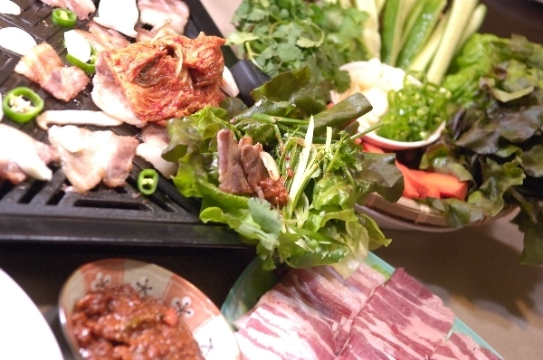 Thịt nướng kiểu Hàn Quốc thường được gói trong rau diếp, cùng tỏi, kim chi, cơm...