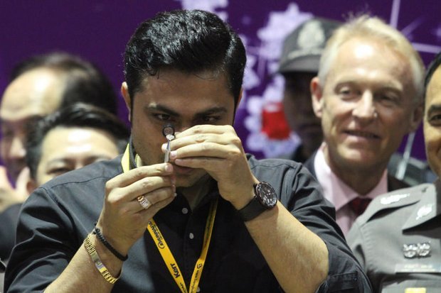 Chuyên gia đá quý thẩm định viên kim cương được lấy ra từ trong bụng của nghi phạm Khương - Ảnh: Bangkok Post
