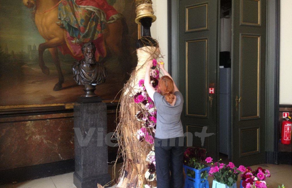 T&aacute;c phẩm người mẫu mặc v&aacute;y phủ hoa thược dược. (Ảnh: Hương Giang/Vietnam+)