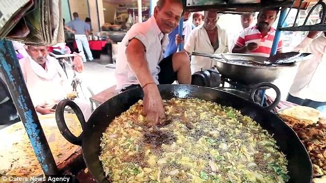 Ram Babu, một đầu bếp 60 tuổi ở thành phố Allahabad (Ấn Độ), đã thu hút hàng trăm thực khách tới ăn món khoai tây chiên nhờ sử dụng tay trần để đảo khoai trong chảo dầu 200 độ C. (Nguồn: CCTVNews)