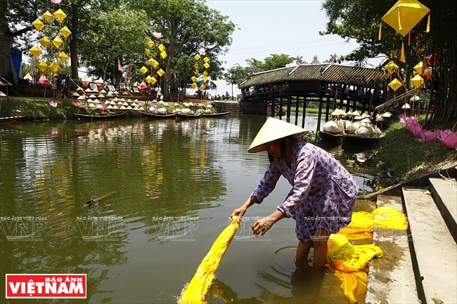 Một cụ bà giặt lụa bên bến sông Như Ý. Ảnh: Thanh Giang/Báo ảnh Việt Nam