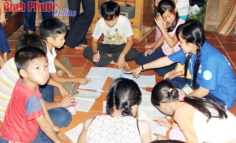 Thanh niên tình nguyện tại huyện Bù Đốp ôn bài cho các em thiếu nhi trong dịp hè