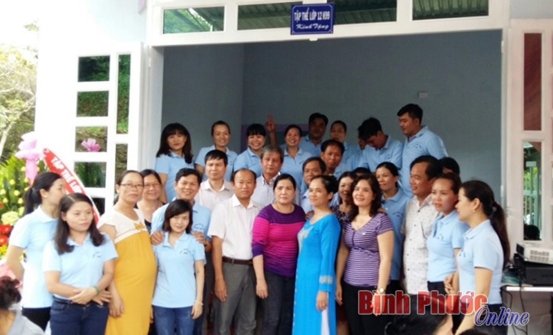 Tập thể cựu học sinh lớp 12K99 Trường THPT Bù Đăng và lãnh đạo chính quyền huyện chúc mừng cô Nguyễn Thị Hường trước căn nhà mới