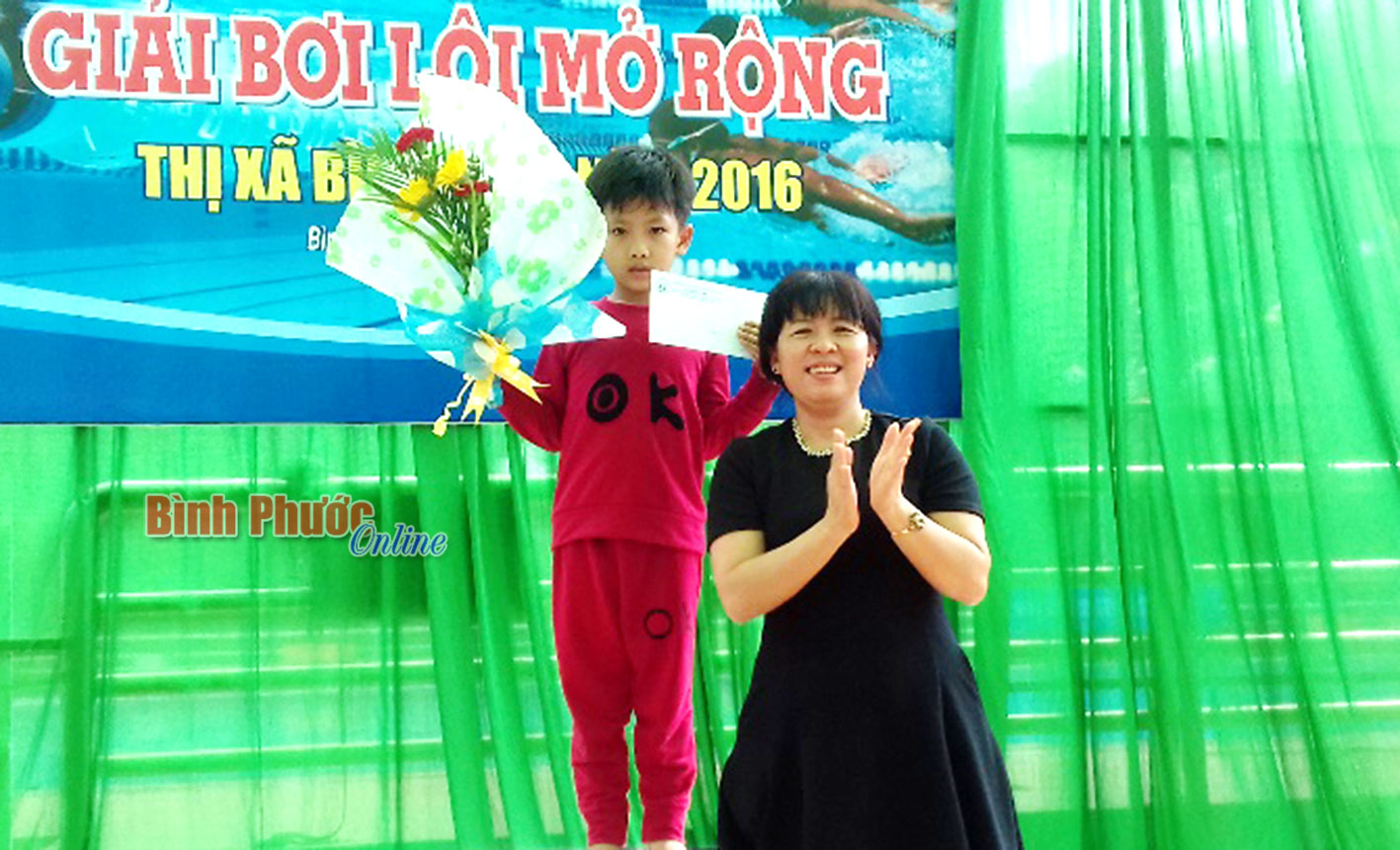 Trưởng ban Tuyên giáo Thị ủy Bình Long Nguyễn Thị Huyền Linh trao giải khích lệ tinh thần thể thao cho VĐV nhỏ tuổi nhất Bùi Đức Minh, SN 2011