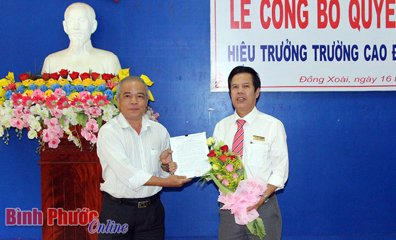Đại diện Tập đoàn Công nghiệp cao su Việt Nam trao quyết định bổ nhiệm hiệu trưởng cho ông Lê Văn Kích (phải)