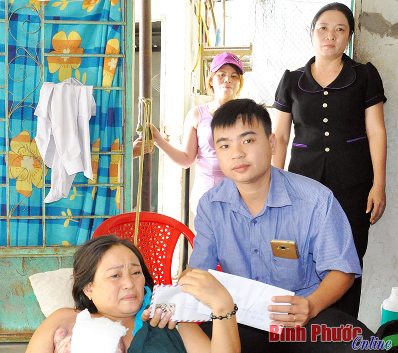 Đại diện nhóm thiện nguyện đến từ tỉnh Bình Dương hỗ trợ tiền, giúp chị Phượng vượt qua nỗi đau bệnh tật