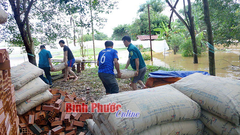 Lực lượng phòng chống thiên tai giúp gia đình ông Trần Văn Sứng, tổ 2, khu phố Xuân Đồng di chuyển vật liệu xây dựng lên chỗ cao
