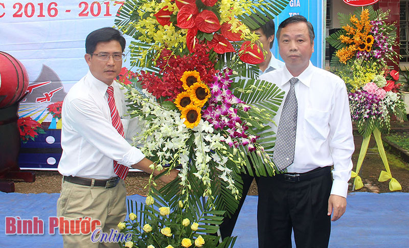 Phó chủ tịch UBND tỉnh Huỳnh Anh Minh (phải) tặng lẵng hoa chúc mừng thầy, trò Trường cấp 2-3 Võ Thị Sáu dịp khai giảng năm học 2016-2017