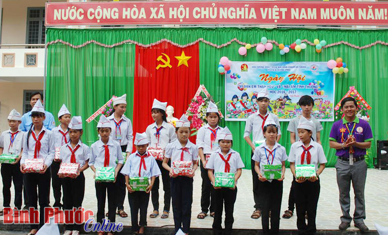 Đại diện Hội đồng đội huyện Đồng Phú và CLB Hoa Chuông Xanh (Đồng Tiến) tặng quà cho học sinh có hoàn cảnh khó khăn vươn lên trong học tập