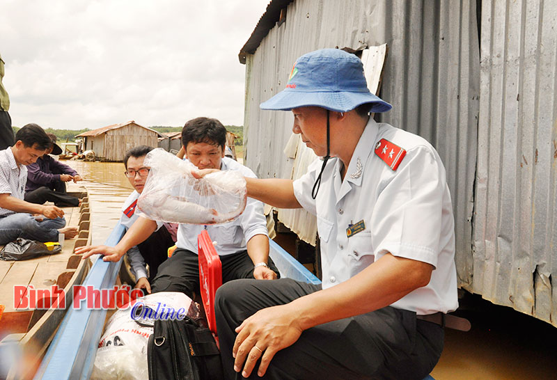 Chánh thanh tra Sở Nông nghiệp và Phát triển nông thôn Trần Chúc lấy mẫu cá lăng nha nuôi lồng bè ở thôn 10, xã Đức Liễu (Bù Đăng) để kiểm tra dư lượng chất cấm và kháng sinh trong nuôi trồng thủy sản.