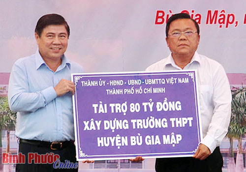 Chủ tịch UBND TP. Hồ Chí Minh Nguyễn Thành Phong (trái) trao tượng trưng 80 tỷ đồng tài trợ xây dựng Trường THPT Bù Gia Mập