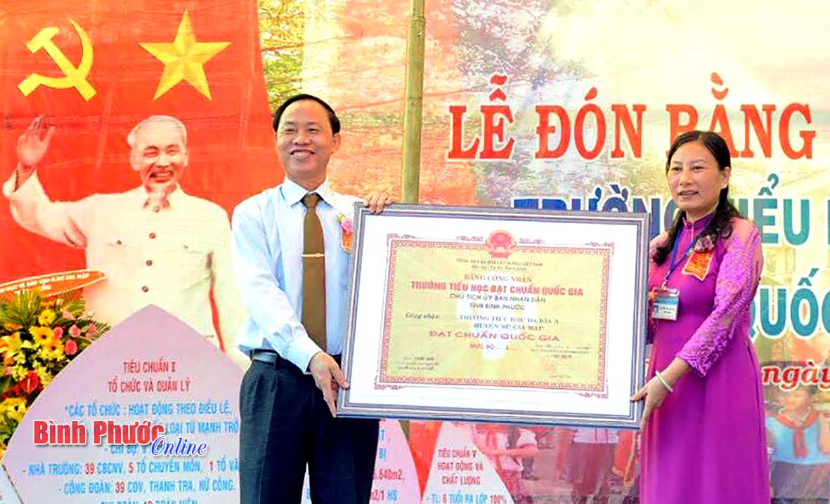 Đại diện Ban giám hiệu trường đón nhận bằng đạt chuẩn quốc gia mức độ 1 - Ảnh: Nguyễn Thắm