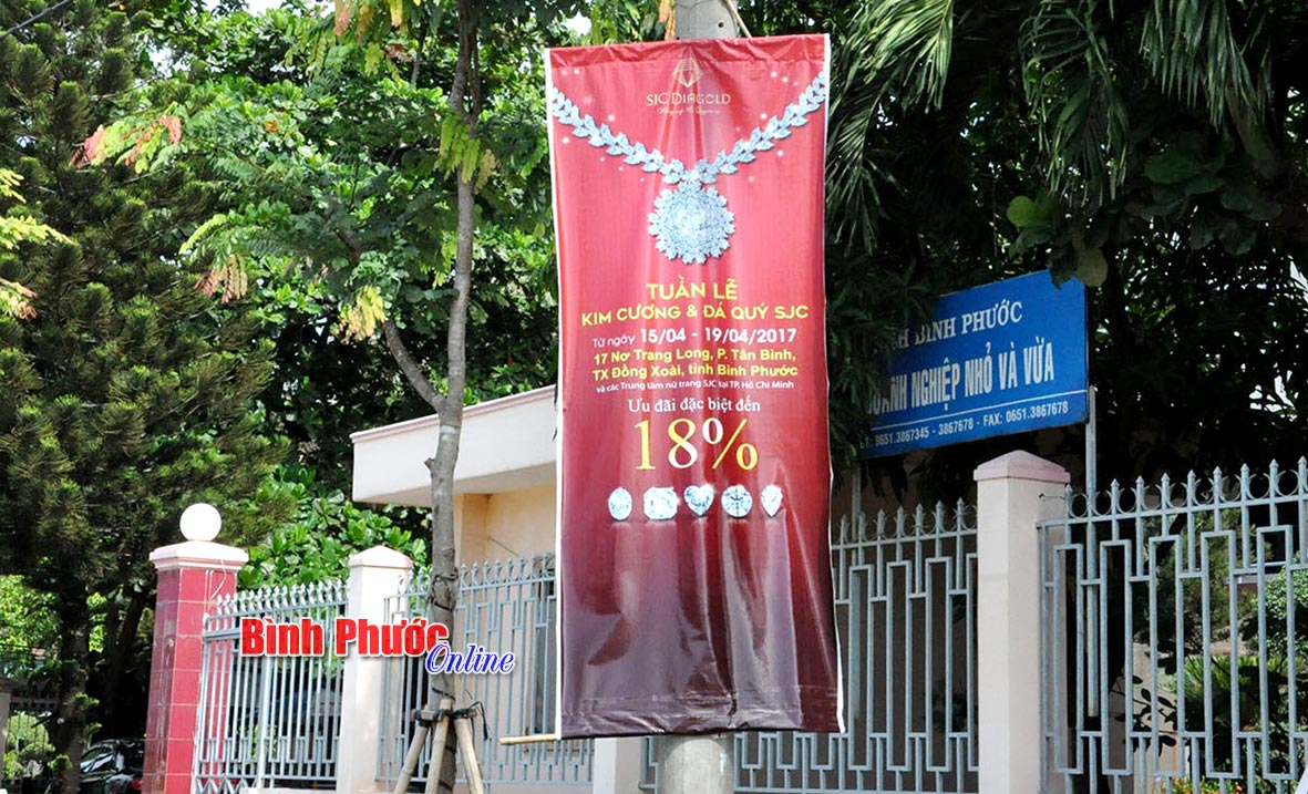 Tường rào của các trường học cũng được “tận dụng” để treo, dán biển quảng cáo (trong ảnh là tường rào Trường mầm non Họa Mi, phường Tân Phú)