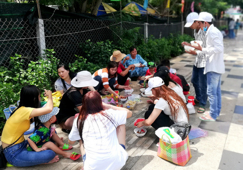 Người dân đi chơi lễ ăn trưa trên vỉa hè đường Thùy Vân. Ảnh: Nguyễn Khoa