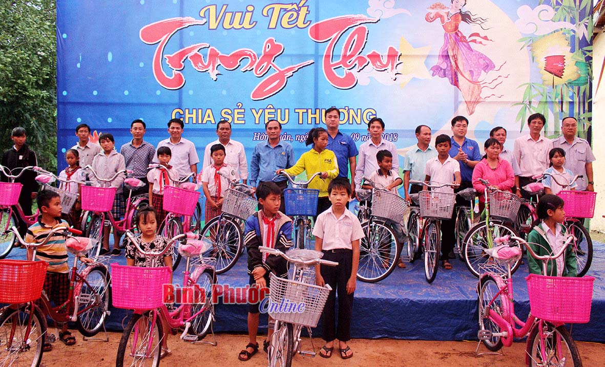 Đại diện lãnh đạo công ty, chính quyền địa phương và các nhà hảo tâm trao xe đạp cho các em có hoàn cảnh khó khăn
