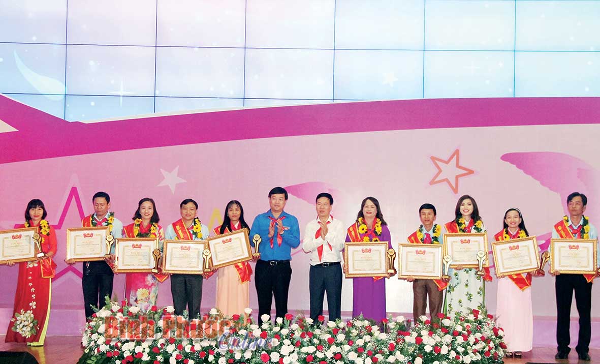 Thầy Tổng phụ trách đội Trường tiểu học Lộc Điền A (Lộc Ninh) Phan Thanh Minh (bìa phải) được vinh danh tại lễ trao giải thưởng “Cánh én hồng” năm 2018