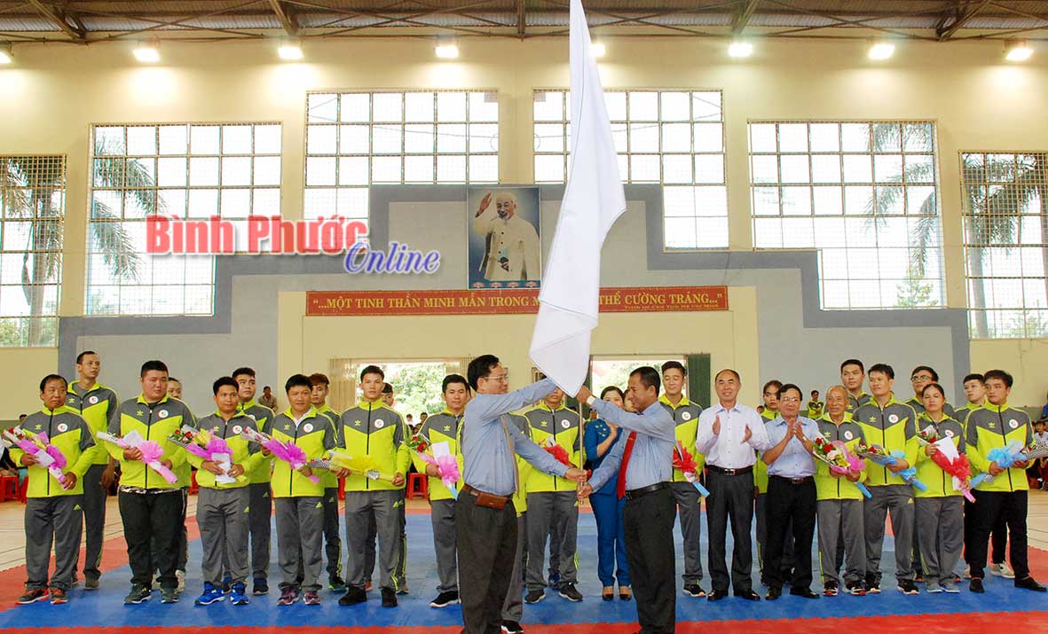 Giám đốc Sở Văn hóa, Thể thao và Du lịch Trần Văn Chung (bên trái) trao cờ xuất quân cho trưởng đoàn thể thao tỉnh tham dự Đại hội thể thao toàn quốc lần thứ 8/2018