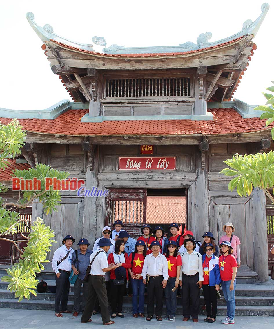 Khách từ đất liền ra thăm đảo chụp hình lưu niệm trước cổng chùa Song Tử Tây