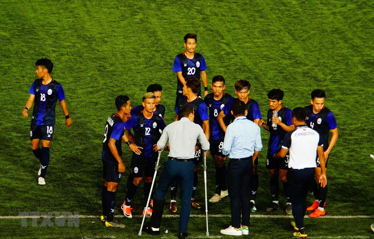Huấn luyện viên U22 Campuchia (chống nạng) chỉ đạo các cầu thủ. (Ảnh: TTXVN)
