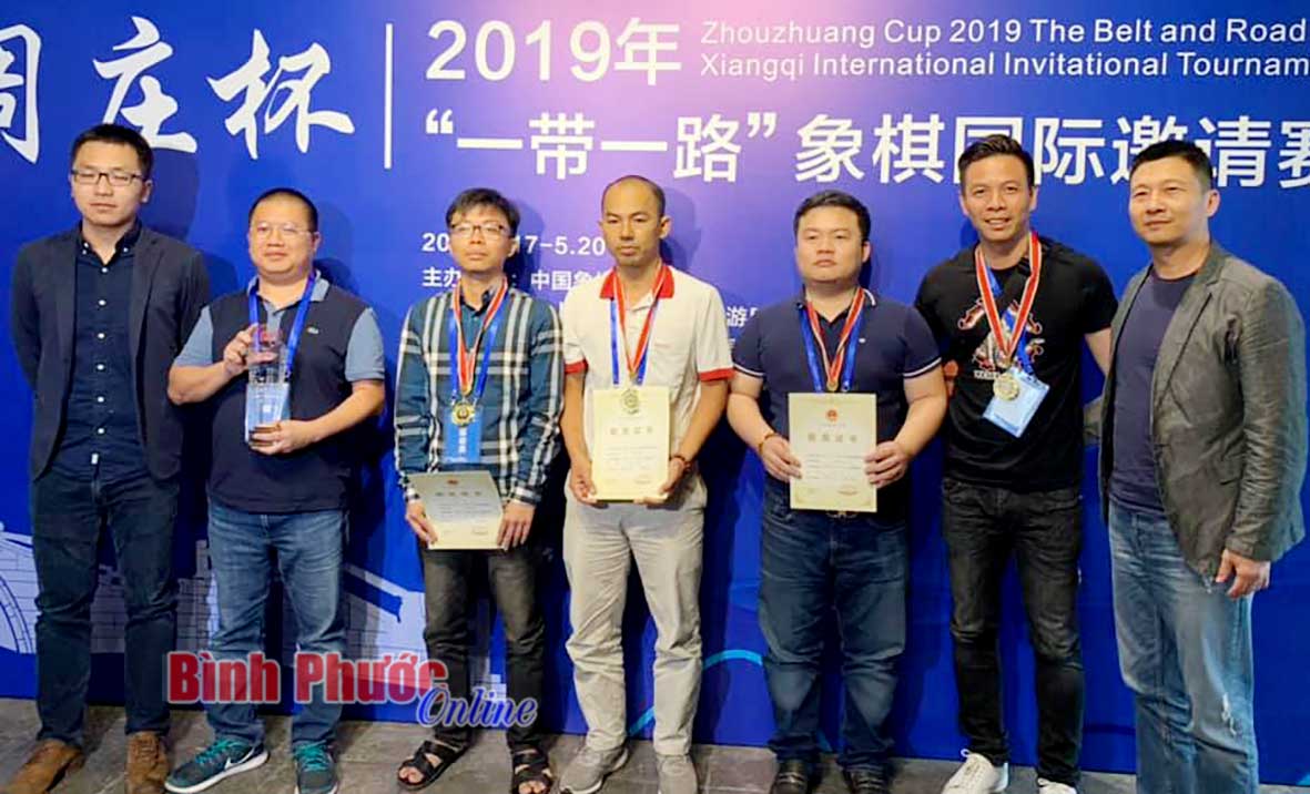 Kỳ thủ Võ Minh Nhất (giữa) và đội tuyển Việt Nam chiến thắng tại giải vô địch cờ tướng đồng đội quốc tế tranh cúp Chu Trang Bôi 2019, trên đất Trung Quốc