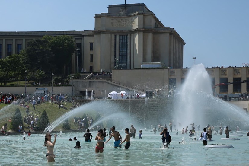Trong ảnh: Người dân giải nhiệt tại một đài phun nước ở Paris ngày 26/6. Ảnh: THX/TTXVN