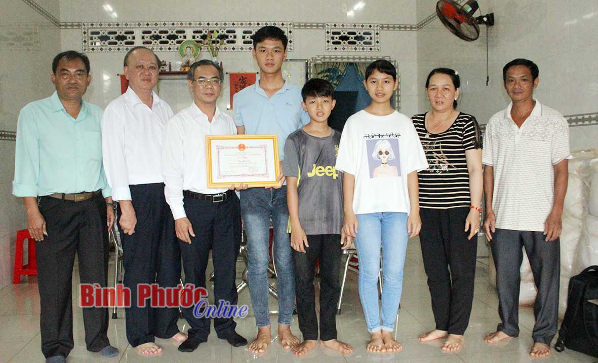 Chủ tịch UBND thị xã Phước Long Phạm Thụy Luân tặng giấy khen cho em Thái Minh Tài