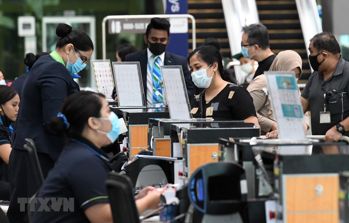 Hành khách làm thủ tục tại sân bay quốc tế Changi ở Singapore ngày 8/6/2020. (Ảnh: AFP/TTXVN)