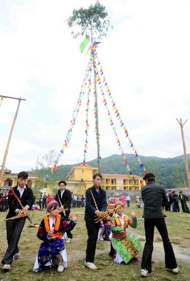 Thanh niên nam nữ dân tộc Mông biểu diễn điệu múa khèn truyền thống tại lễ hội