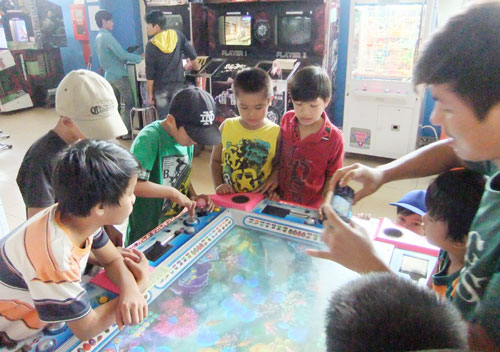 Những ngày hè, có nhiều học sinh ở thị xã Đồng Xoài mê mẩn với trò thua - được trong bàn bắn cá ở trung tâm trò chơi “Game center” ở Siêu thị Co.op mart Đồng Xoài