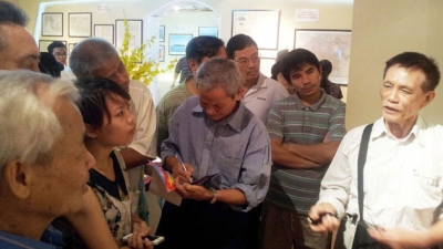 TS Mai Hồng (ngoài cùng bên phải) đang chú giải cho khách thăm quan về bản đồ Hoàng triều trực tỉnh địa dư toàn đồ.