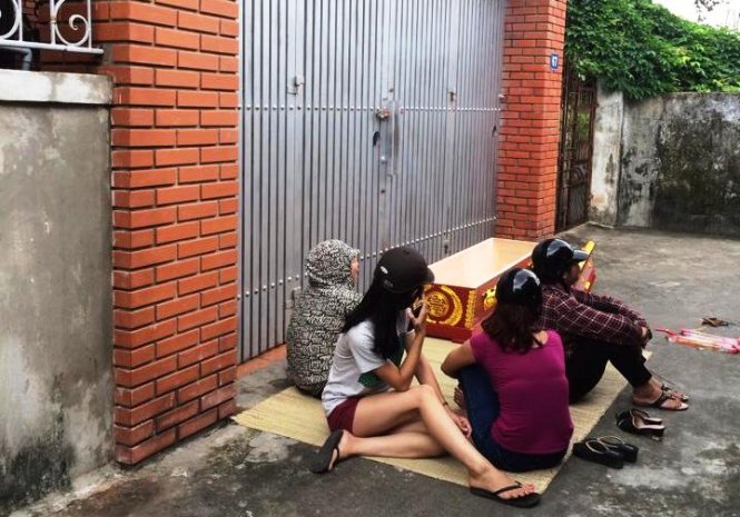 Nh&oacute;m người mang quan t&agrave;i đặt trước cổng nh&agrave; &ocirc;ng H&ograve;a - Ảnh: C.P