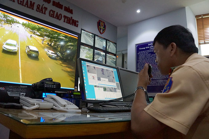 Cảnh s&aacute;t giao th&ocirc;ng C&ocirc;ng an TP Bi&ecirc;n H&ograve;a theo d&otilde;i người tham gia giao th&ocirc;ng. Nếu xe vi phạm, người trực trung t&acirc;m b&aacute;o qua bộ đ&agrave;m cho cảnh s&aacute;t giao th&ocirc;ng đang chốt ngo&agrave;i đường xử phạt - Ảnh: H&agrave; Mi