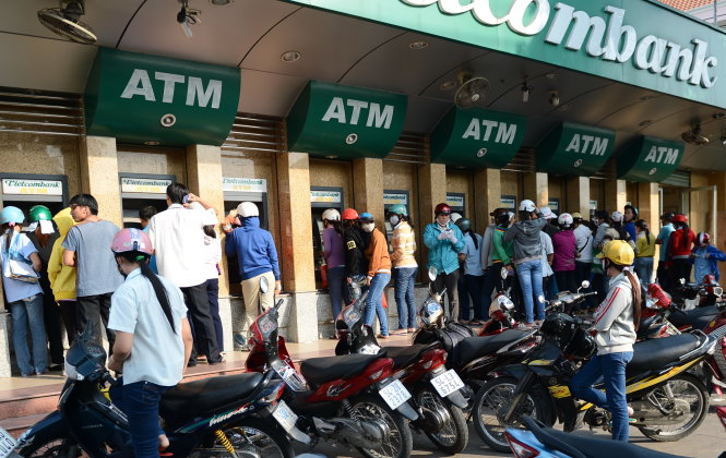 Nhiều công nhân hiện phải tăng ca mới đủ chi phí để trang trải mức sống tối thiểu. Trong ảnh: công nhân rút tiền tại KCX Tân Thuận, Q.7, TP.HCM - Ảnh: Thuận Thắng