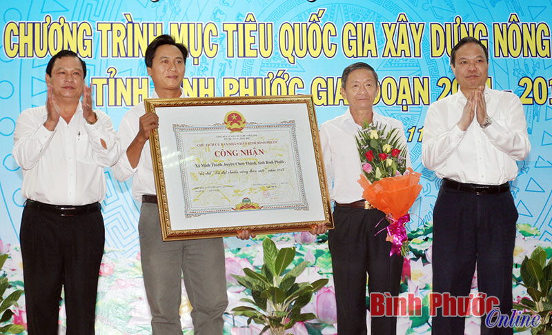 Chủ tịch UBND tỉnh Nguyễn Văn Trăm và Phó bí thư Tỉnh ủy Lê Văn Châu tặng hoa và bằng công nhận xã đạt NTM cho xã Minh Thành, huyện Chơn Thành