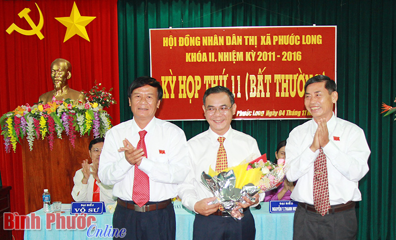 B&iacute; thư Thị ủy Nguyễn Ho&agrave;ng Th&aacute;i v&agrave; Chủ tịch UBND thị x&atilde; Mai Xu&acirc;n Cường tặng hoa ch&uacute;c mừng t&acirc;n Ph&oacute; chủ tịch Phạm Thụy Lu&acirc;n