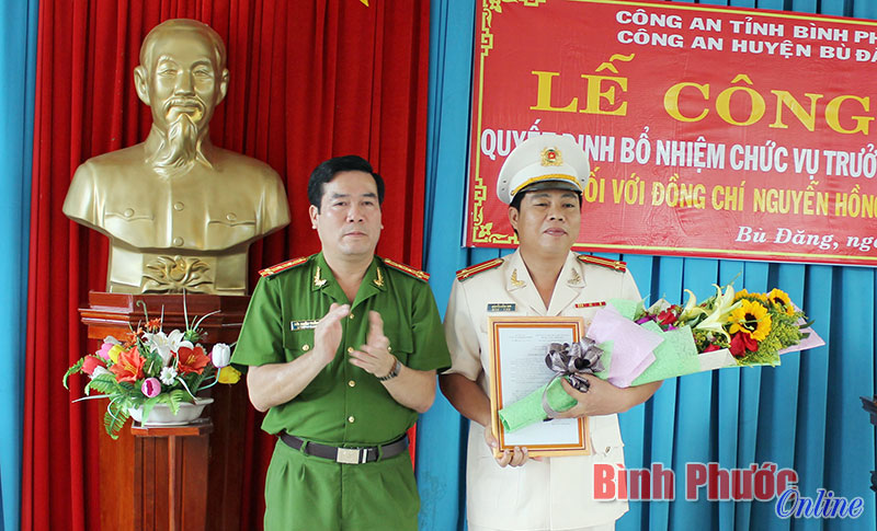 Đại tá Bùi Xuân Thắng trao quyết định và tặng hoa Trung tá Nguyễn Hồng Sơn