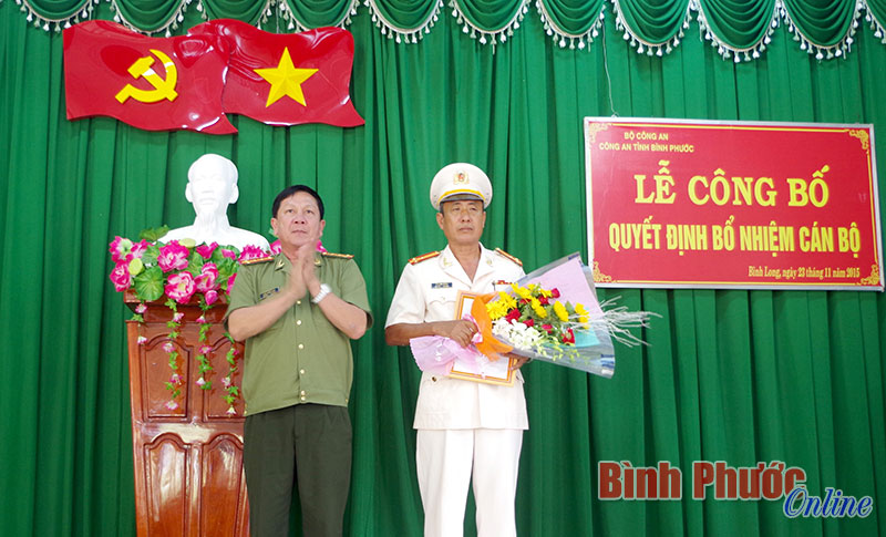 Đại tá Trần Thắng Phúc trao quyết định và tặng hoa chúc mừng Thượng tá Vũ Xuân Bưởng