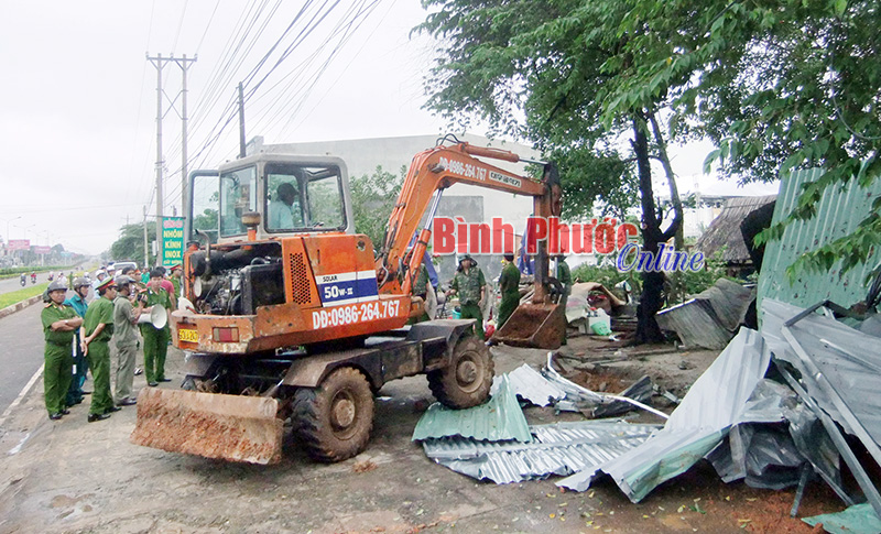 Lực lượng chức năng cưỡng chế giải tỏa căn nhà dựng trái phép ở thị xã Đồng Xoài - Ảnh: S.H