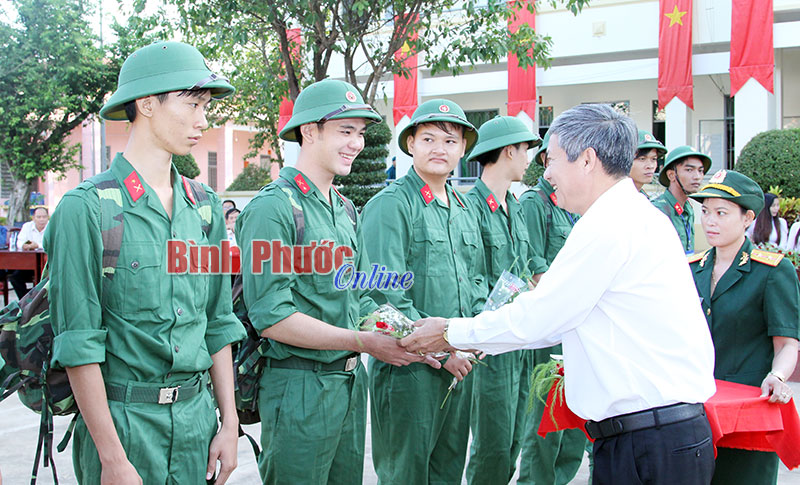 Ủy viên Ban Thường vụ Tỉnh ủy, Bí thư Thị ủy Đồng Xoài Huỳnh Quang Tiên tặng hoa chúc mừng các tân binh lên đường nhập ngũ - Ảnh: Sỹ Hòa