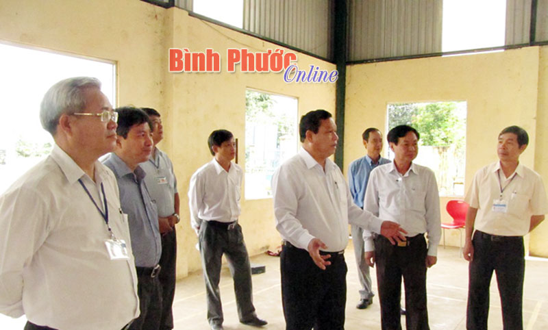 Chủ tịch UBND tỉnh Nguyễn Văn Trăm (đứng giữa) và các thành viên trong đoàn kiểm tra tham quan nhà tập đa năng của xã Tân Lập - Ảnh: M.Luận