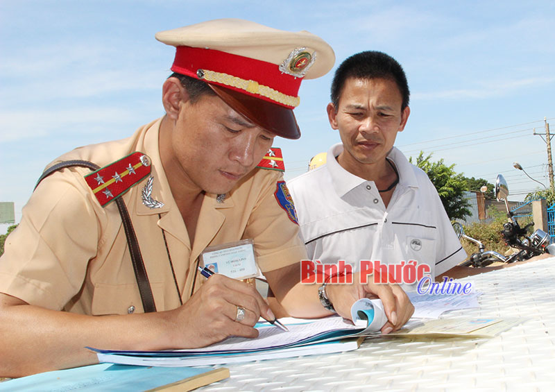 Đại úy Vũ Hoài Linh (Trạm CSGT Đồng Phú) lập biên bản các trường hợp vi phạm