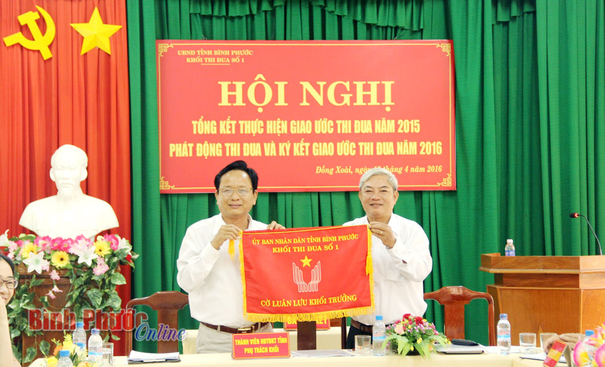 Tổng Bi&ecirc;n tập B&aacute;o B&igrave;nh Phước Đo&agrave;n Như Vi&ecirc;n, Khối trưởng Khối thi đua số 1 năm 2015 trao cờ lu&acirc;n lưu cho đồng ch&iacute; L&ecirc; Văn Uy, Trưởng ban Nội ch&iacute;nh Tỉnh ủy, Trưởng khối thi đua số 1 năm 2016