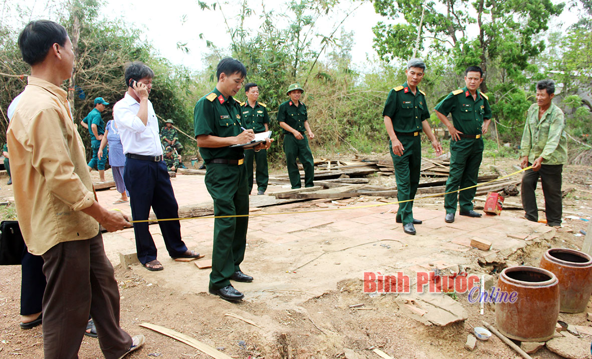 Cán bộ, chiến sĩ Ban CHQS thị xã Đồng Xoài bàn phương án dựng lại nhà cho bà Vũ Thị Nụ