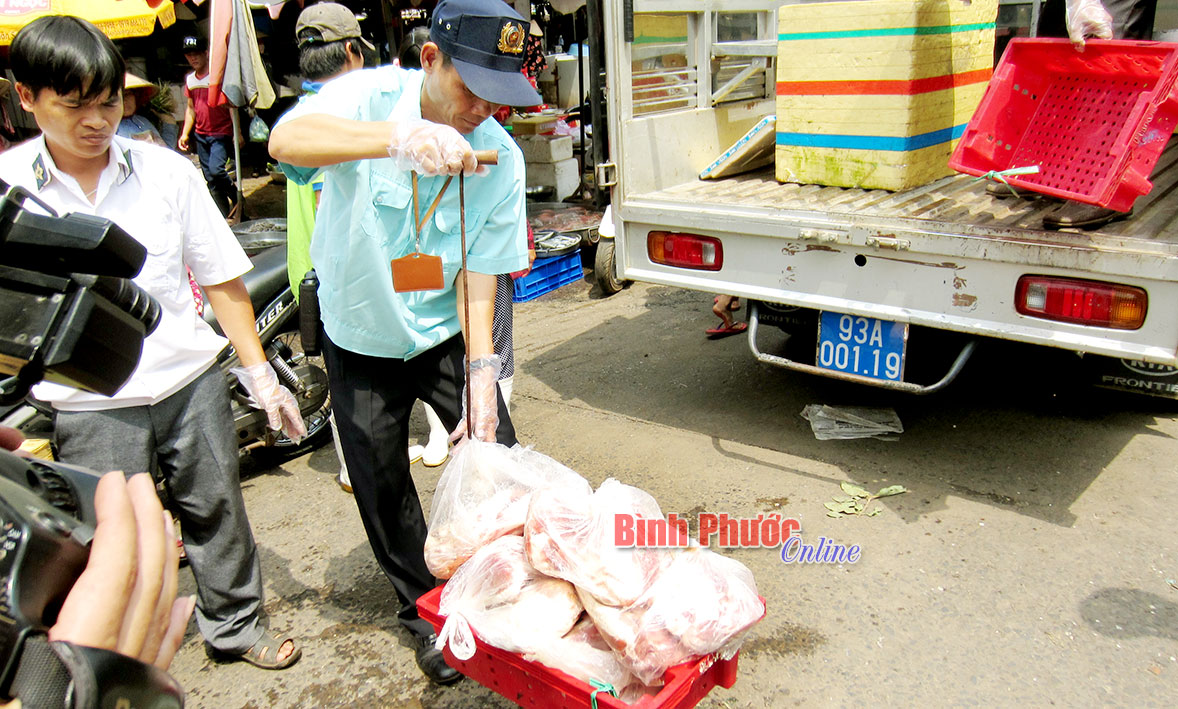 Đoàn kiểm tra tịch thu thịt thối tại chợ Đồng Xoài ngày 10-5 - Ảnh: K.Phụng